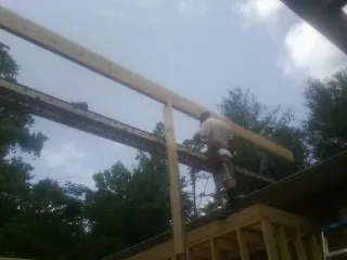 Carpenter setting a ridge beam over a new addition frame — Ice Dam Removal by Roofing Brothers in Cape Neddick