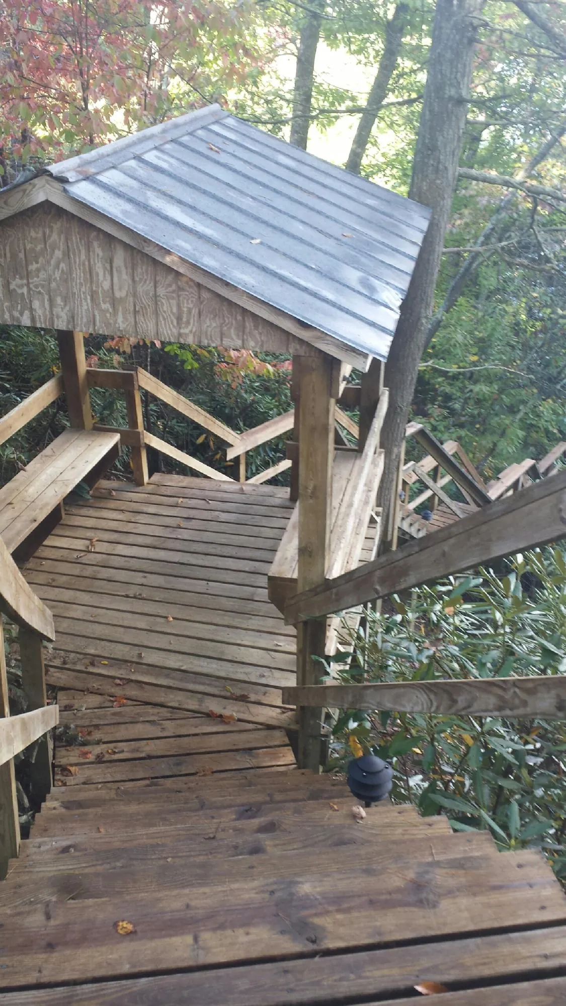 Metal roofed shelter over wooden steps on a wooded walkway — Skylight Repair & Installation work by our crew in Cape Neddick